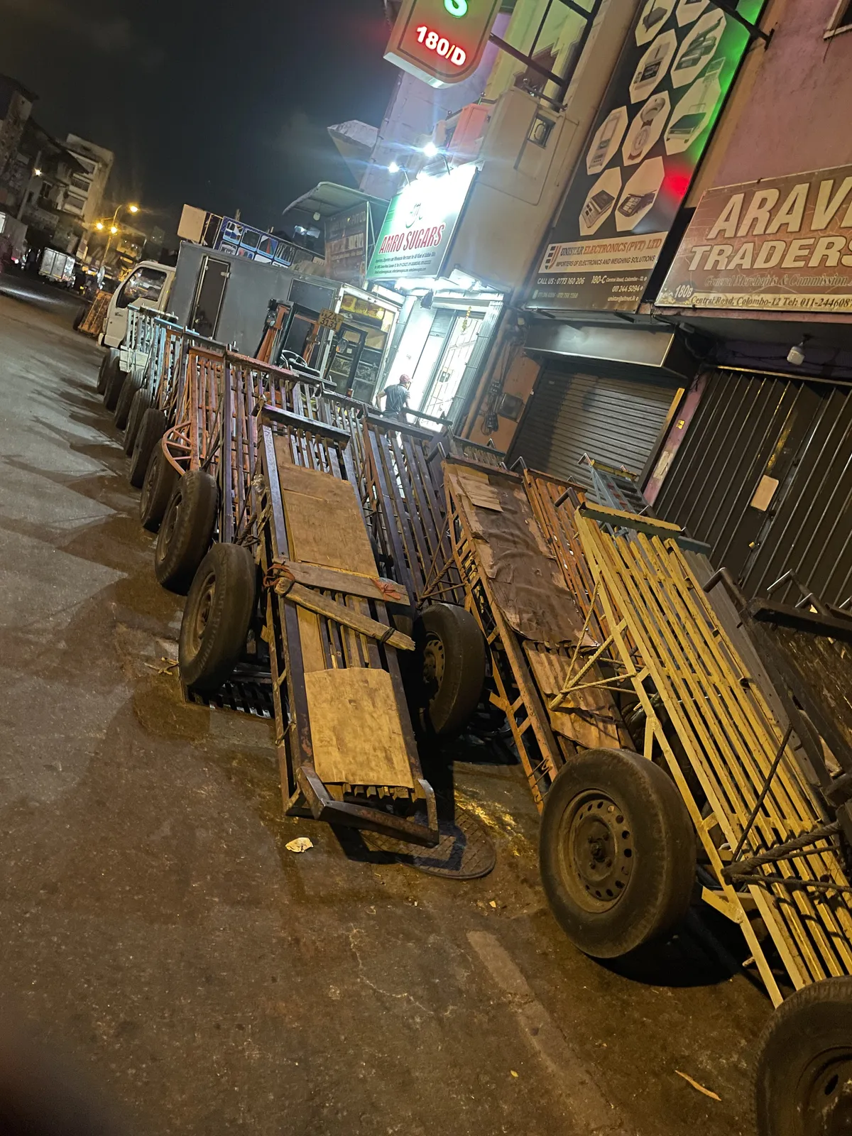 Wooden hand-pull carts lined up at night outside shops in Pettah Market, Colombo
