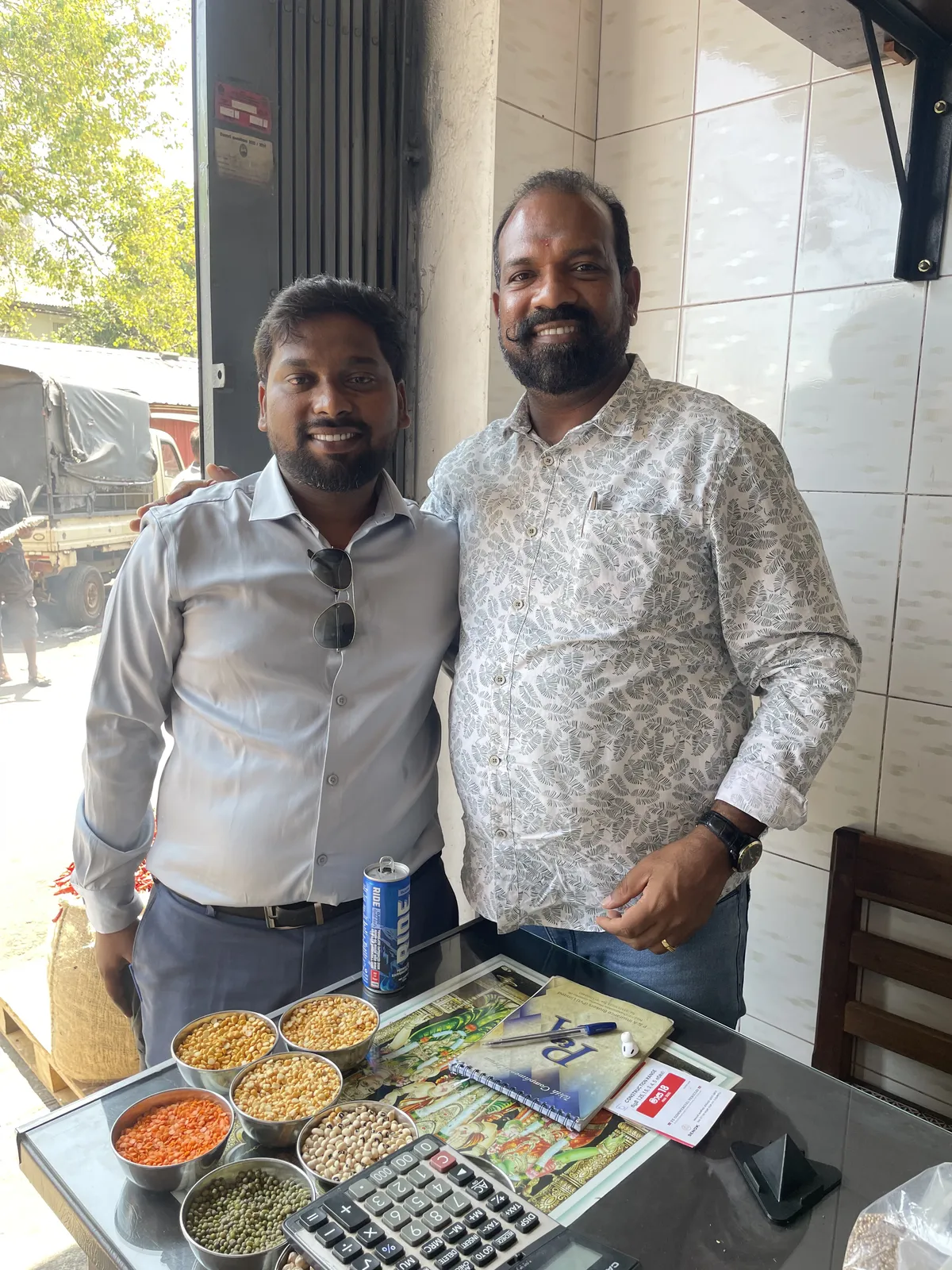 Rahul Govindu with a pulses trader at his Pettah Market shop, sample bowls of dals on the counter